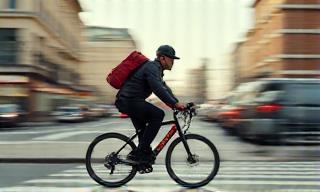 Coursier vélo traversant la ville